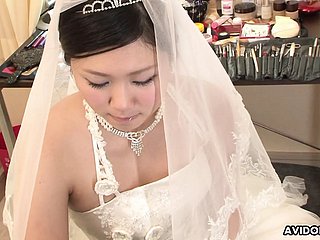 黑发Emi Koizumi在未经审查的婚纱上性交。