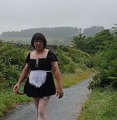 Cameriera travestita respecting una strada pubblica sotto dampen pioggia